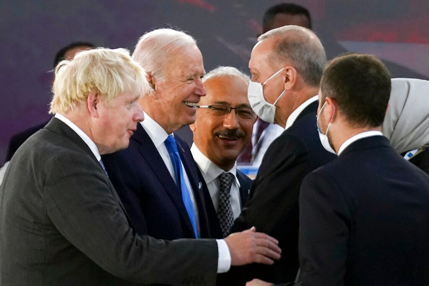 Joe Biden shakes Recep Tayyip Erdogan's hand as Boris Johnson watches on.