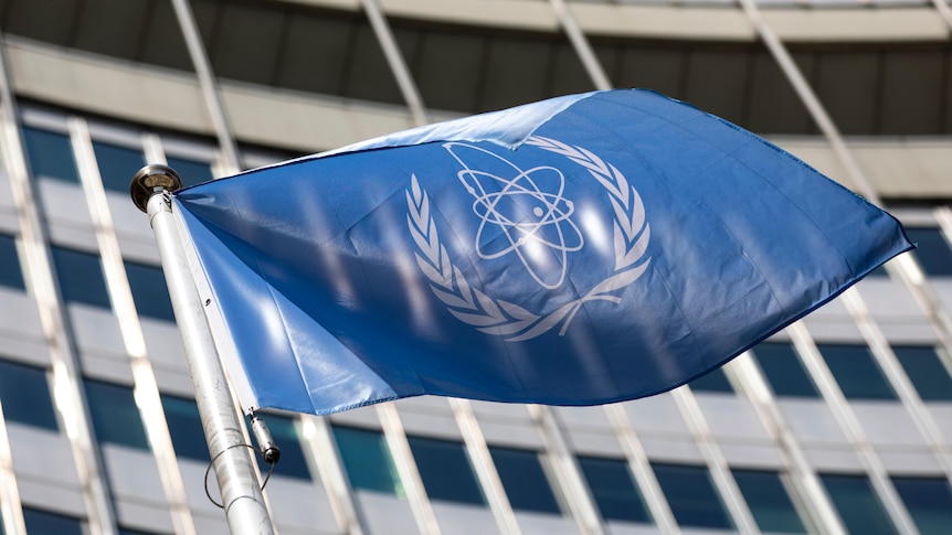 The blue flag of the International Atomic Energy Agency waves.