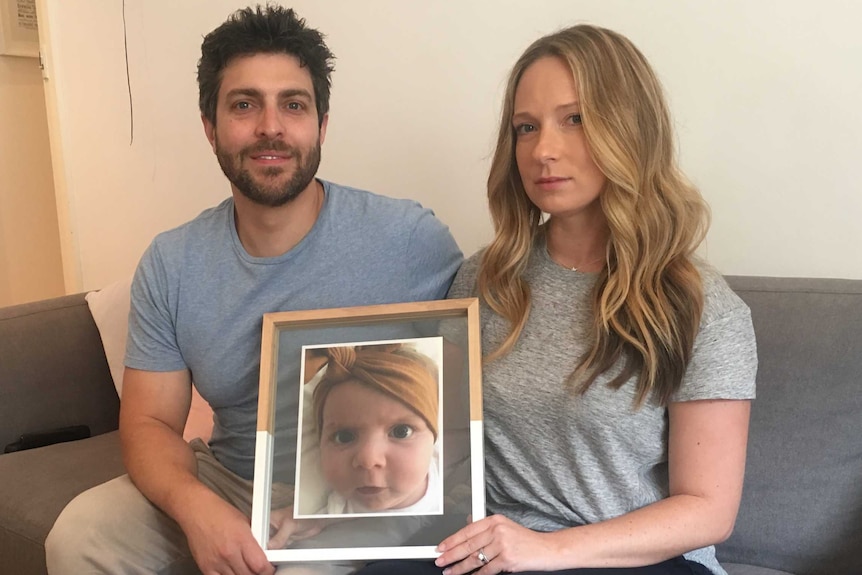 Rachael and Jonny Casella hold a photo of their late daughter Mackenzie