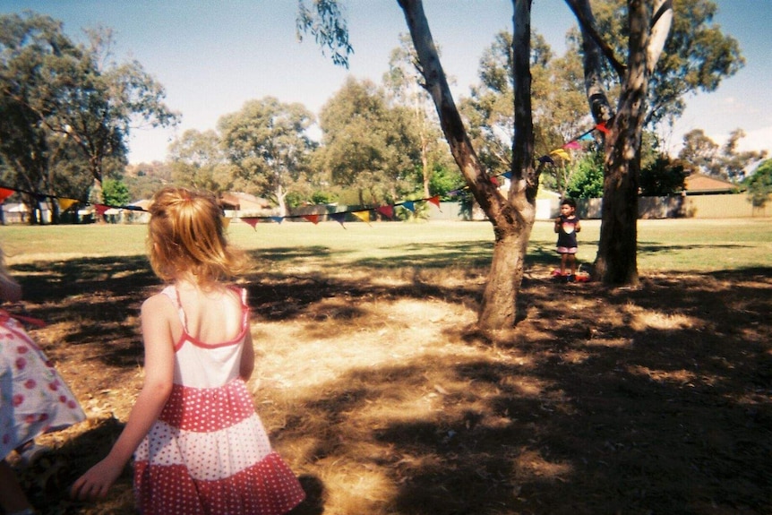 A young girl looks at bunting in park