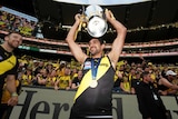 Richmond Tigers player Marlion Pickett celebrates grand final win holding up cup smiling in front of crowd