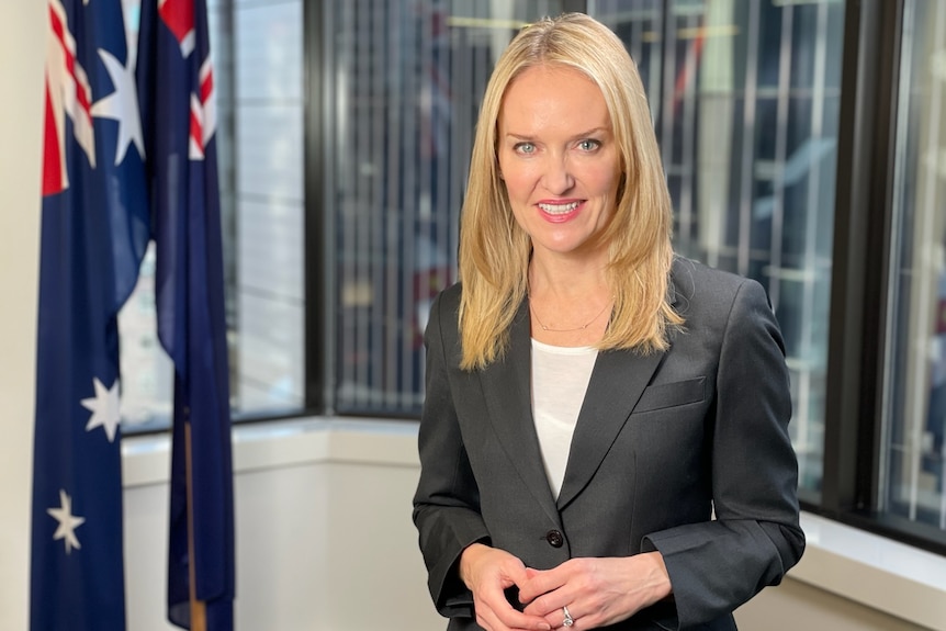 A woman wearing a suit smiles.