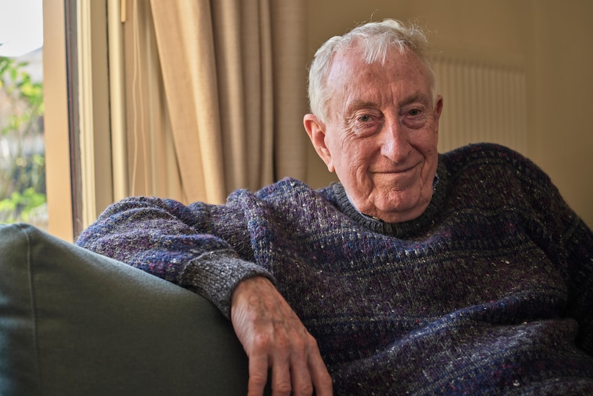 Peter Doherty smiles while sitting on his couch at his home.