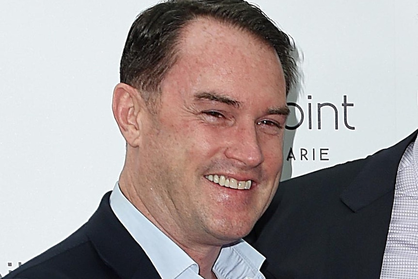 Upper body photo of real estate agency founder John McGrath, smiling