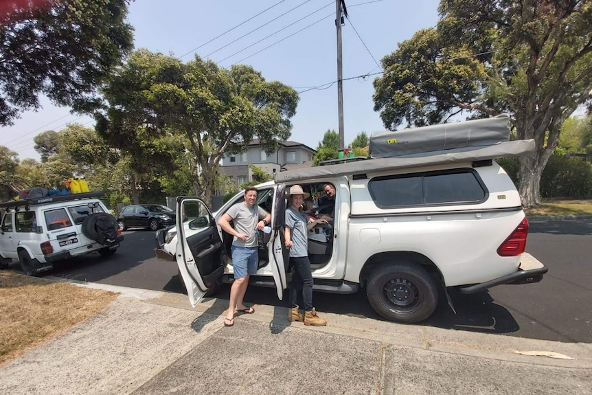 Mr O'Connor and his family smile at camera, leaning on their 4WD hire.