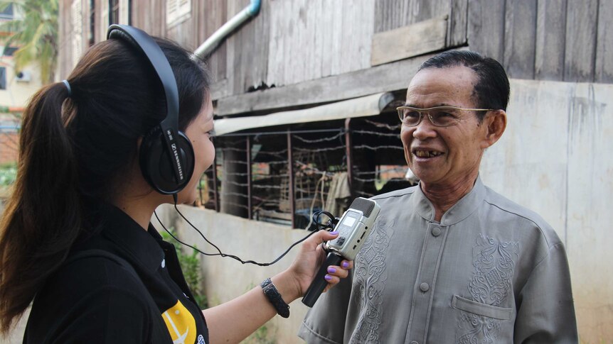 Cambodia - girl interviewing older man on the street