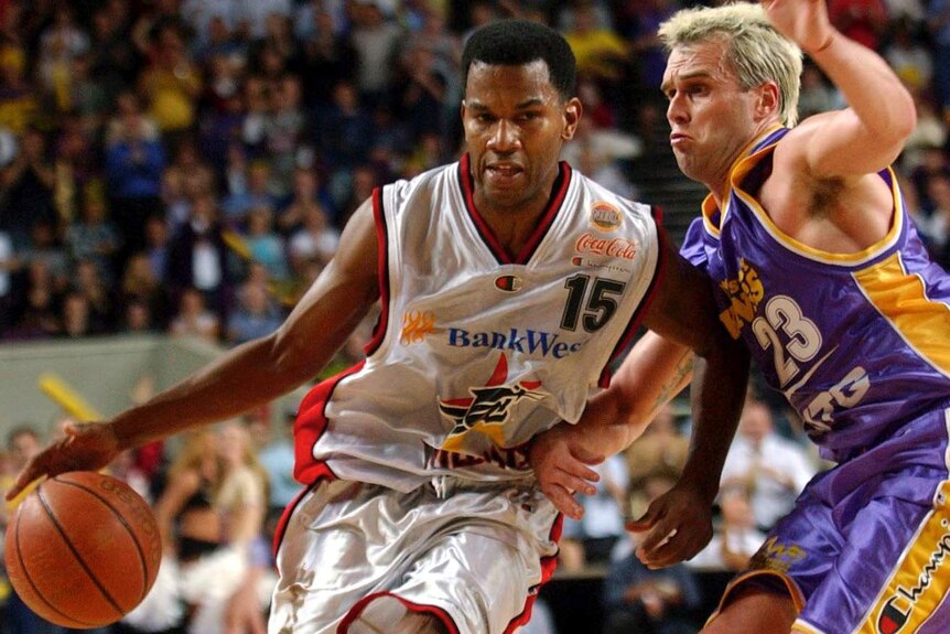 Perth Wildcats guard Ricky Grace dribbles the ball around Sydney Kings opponent Shane Heal.