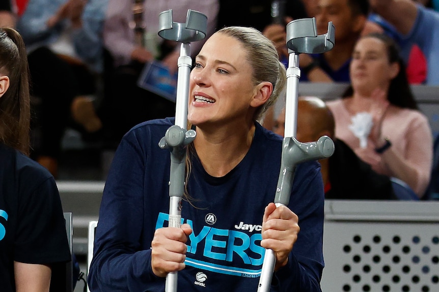 Lauren Jackson holds a pair of crutches