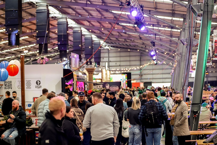 Hall of attendees at a beer festival alongside exhibitor booths.