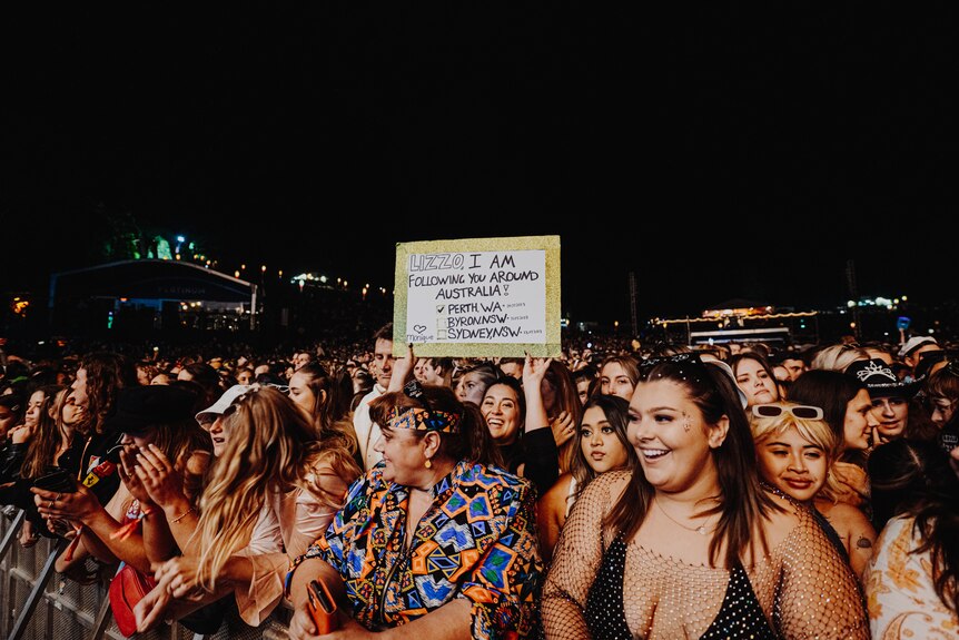 Crowd photo at Lizzo's splendour set shows a fan holding up a homemade sign