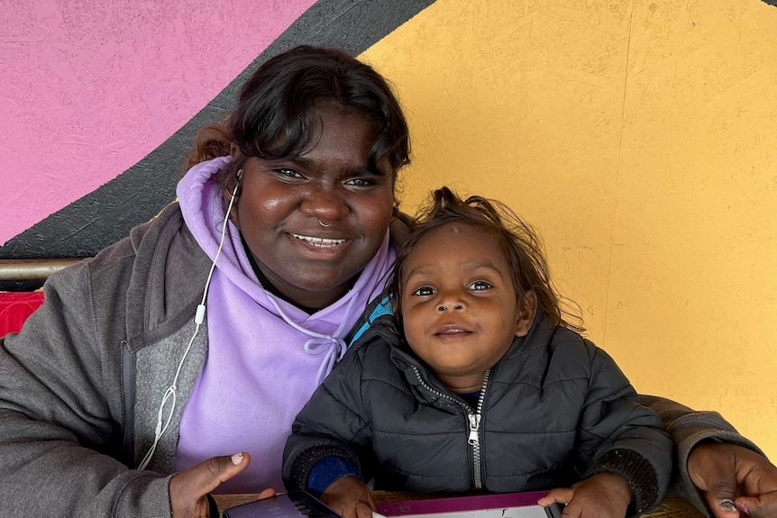 two aboriginal sisters drawing together