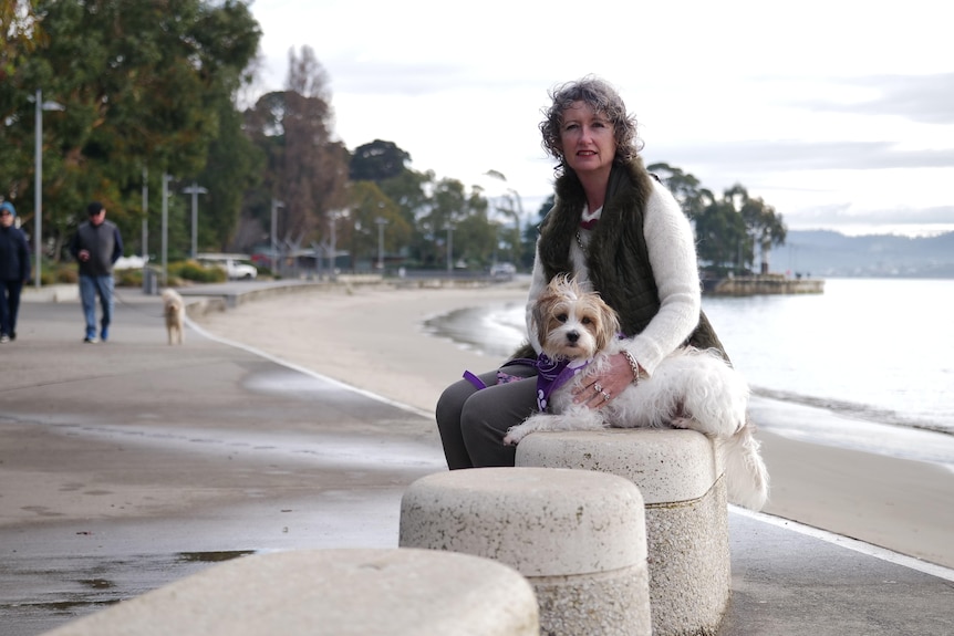 Judi Adams sitting on a concrete seat by the water.