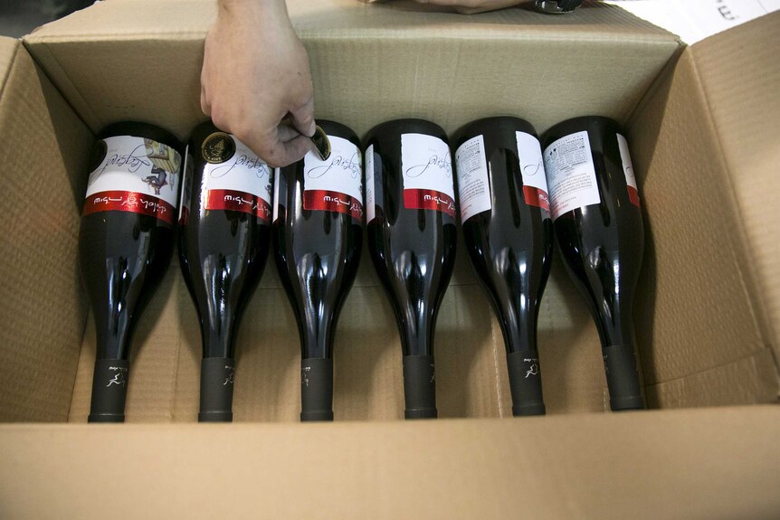 A worker places stickers on wine bottles at Shiloh Wineries.