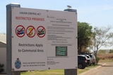A sign in front of public housing complex states that liquor restrictions apply to the premises and $2,000 fines can apply