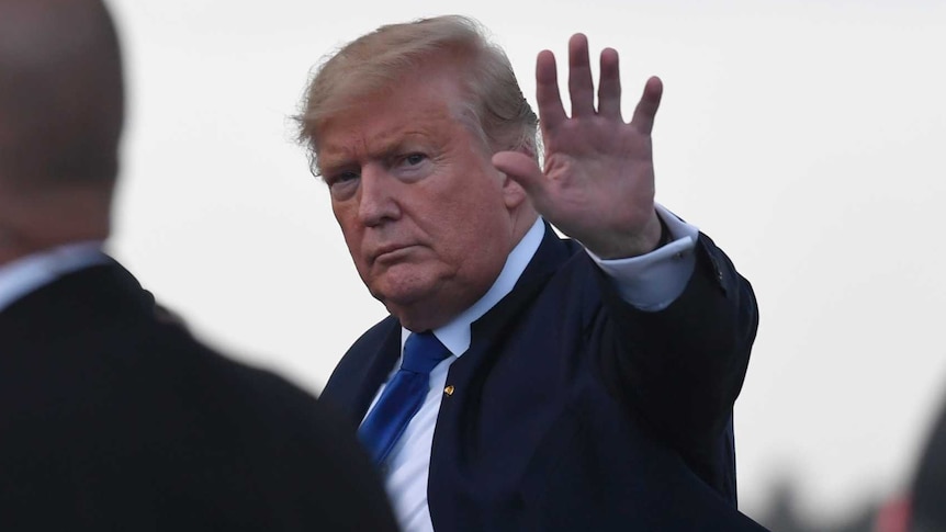 President Donald Trump waves before getting into his vehicle.