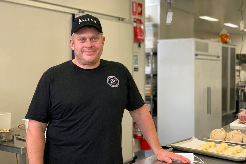 Jerome Dalton stands at a work bench at his catering business in Brisbane