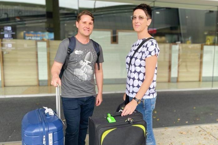 Cameron Francis and Kate Jones at Brisbane Airport with luggage.