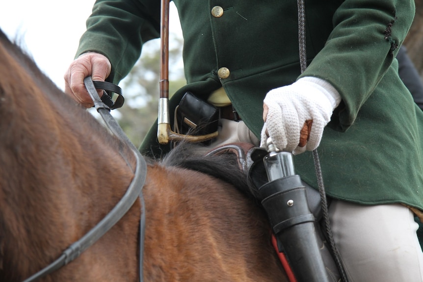 Close up of a drink bottle holder on the side of a saddle.