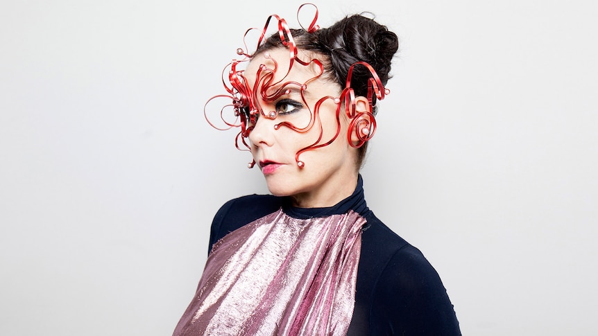 Bjork looks to the side with her face surrounded by red tentacles
