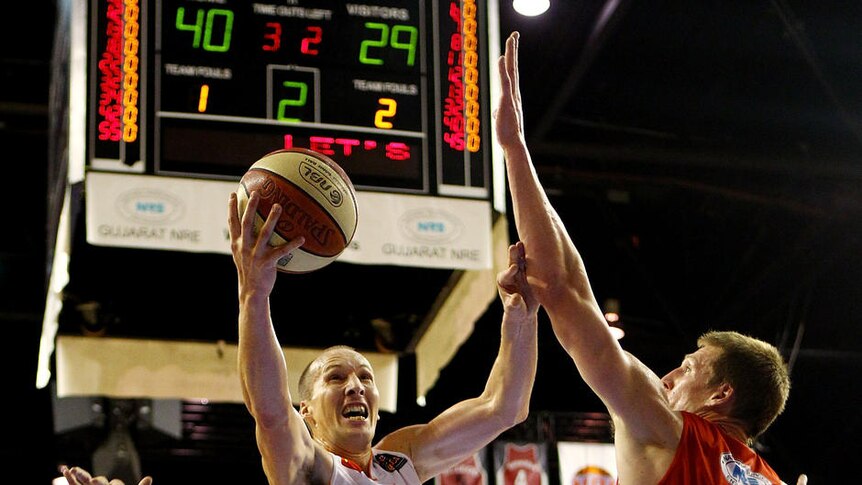 Phill Jones of the Taipans drives to the basket against the Hawks.