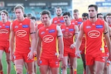 Gold Coast players look downcast as they leave the field