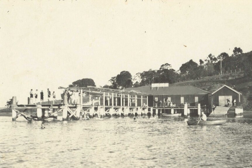 Sepia photograph of wooden house and jetty on the river at Cornelian Bay