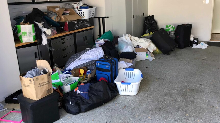 Cases, boxes and laundry baskets piled up in the garage at a short stay rental property.