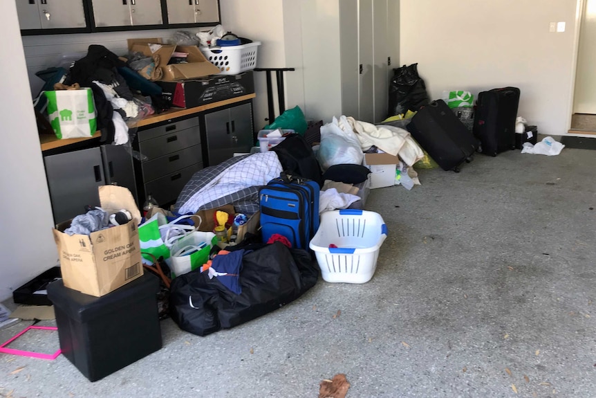 Cases, boxes and laundry baskets piled up in the garage at a short stay rental property.