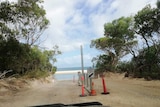A steel pole at the entrance to a beach.