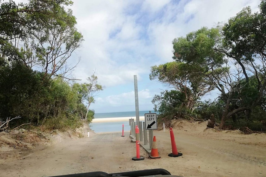 A steel pole at the entrance to a beach.
