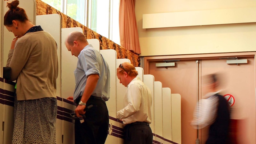 Three unidentified voters at polling booths and one walking. Arty movement photo for ACT election. Oct 2012.