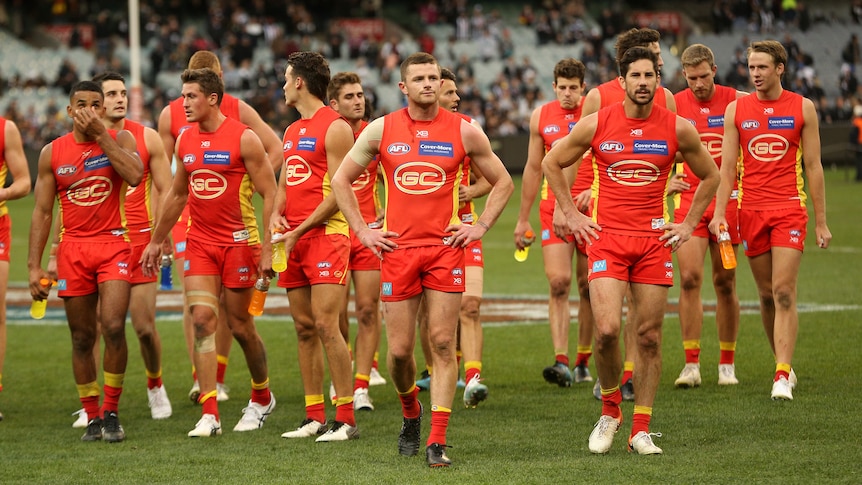 The Gold Coast Suns walking from the field.