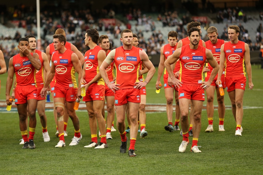 The Gold Coast Suns stand around dejectedly after a defeat in the AFL