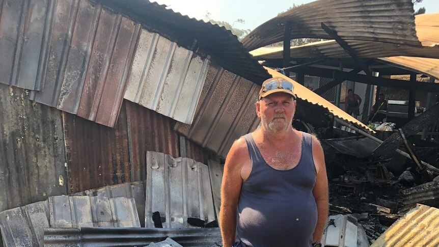 Karl Fisher in front of his family’s home at Mount Larcom after a bushfire.
