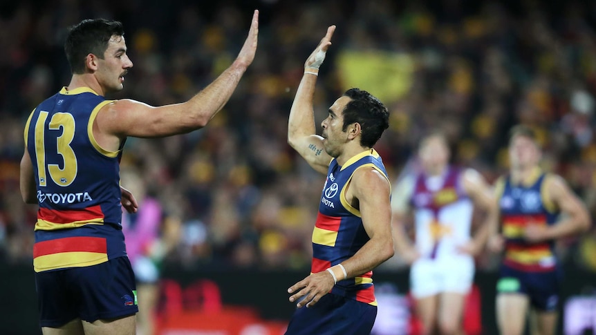 Taylor Walker of the Crows congratulates team mate Eddie Betts after kicking a goal