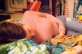 A woman suffering from pelvic pain lies on her bed