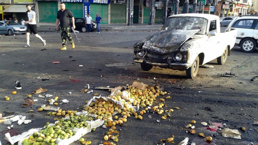 Syrians inspect the site of a suicide attack in Sweida