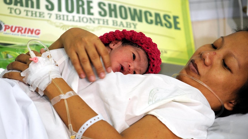 7 billion and counting: Danica Camacho is coddled by her mother Camille at a hospital in Manila.