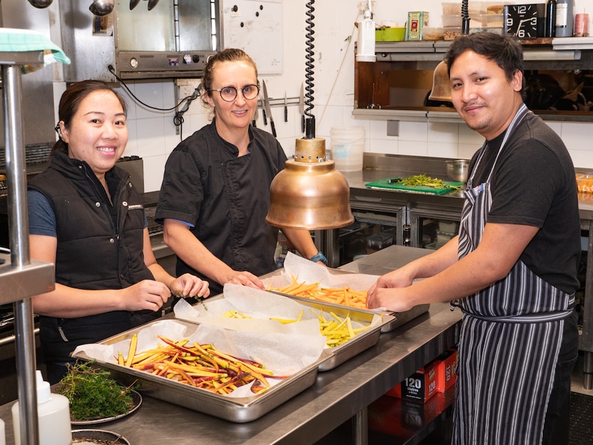 Lolli Redini restaurateur Simonn Hawke with two kitchen workers.