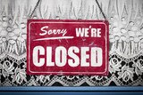 Sorry we're closed sign hanging in store window.