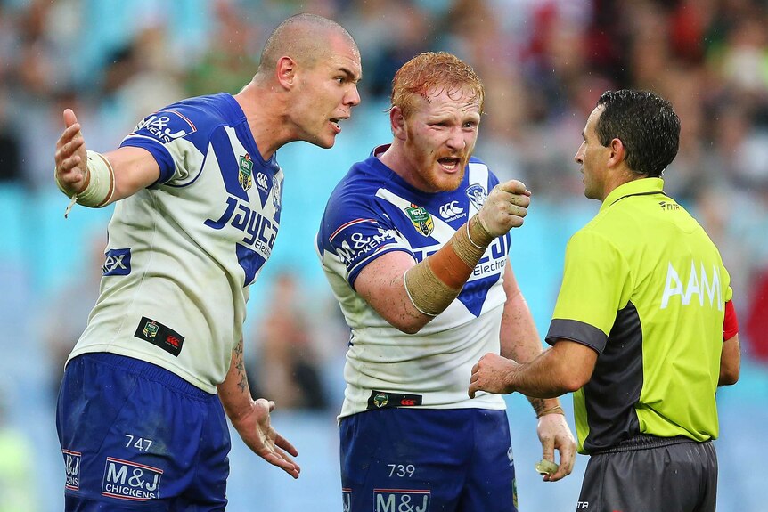 David Klemmer and James Graham of the Bulldogs confront referee Gerard Sutton against South Sydney.