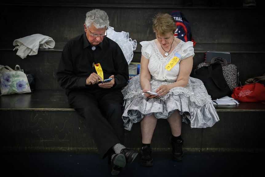 Square dancers looking at smartphones