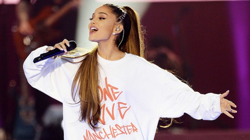 Ariana Grande holds a microphone as she sings at the One Love Manchester concert.