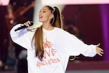 Ariana Grande holds a microphone as she sings at the One Love Manchester concert.