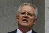 Scott Morrison addresses the media in a pink tie standing in a marble courtyard