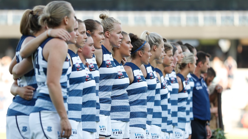 Geelong AFLW players line up for the national anthem during a 2019 premiership match.