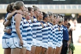 Geelong AFLW players line up for the national anthem during a 2019 premiership match.