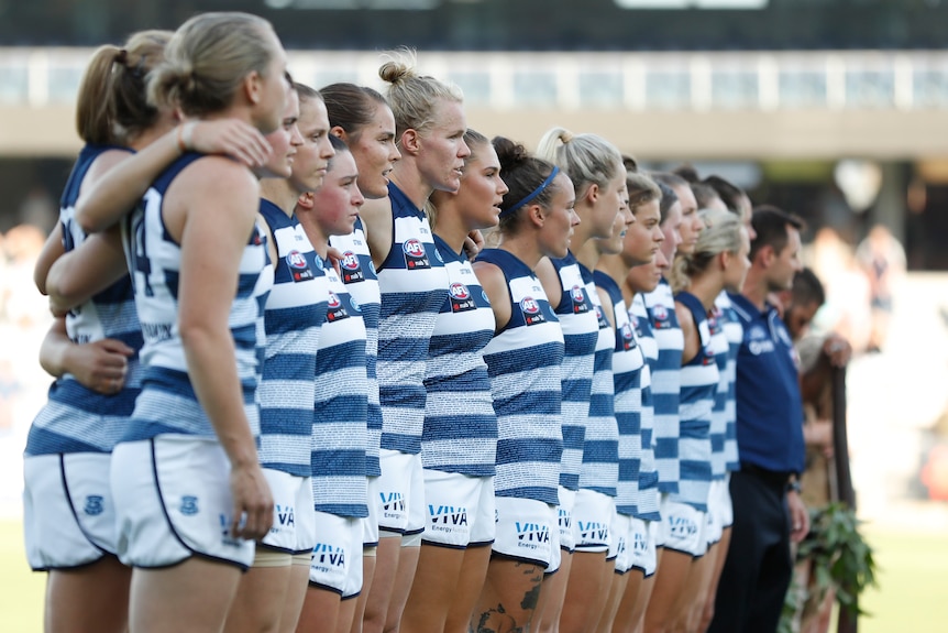 Geelong AFLW players line up for the national anthem during a 2019 premiership match.