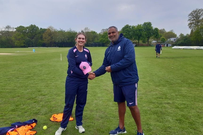 Horley receives her pink and navy Middlesex cap from the coach before her debut