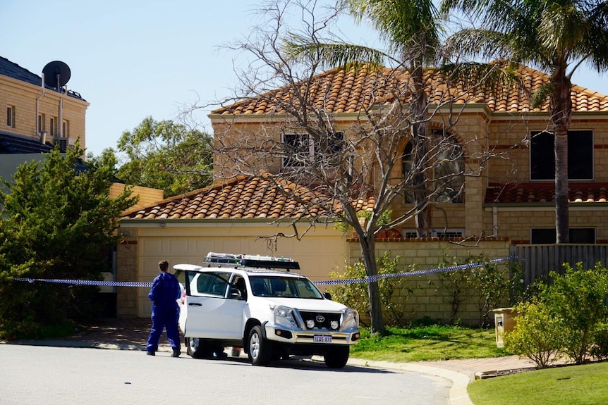 Police at the house of a woman who was killed and stuffed into a suitcase.